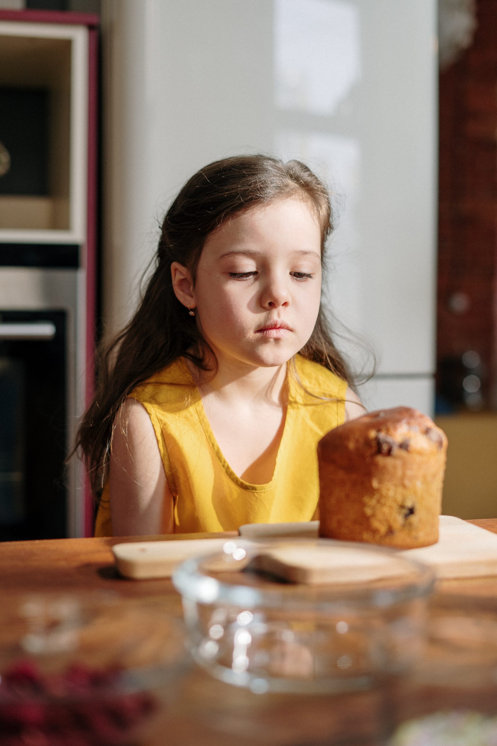 little girl looking at muffin